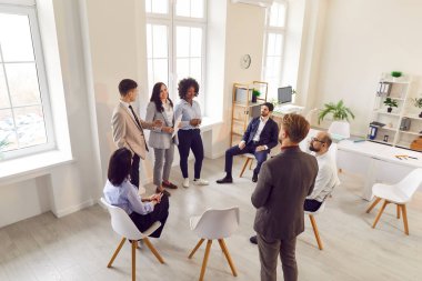 Bir grup farklı iş adamı ofiste toplanırken sohbet ediyorlar. Şirket çalışanları iş projesini tartışıyor. İş arkadaşları meslektaşlarını dinler. Şirket iş ekibi konsepti.