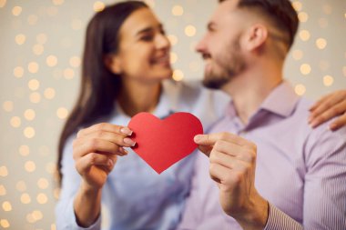 Mutlu bir çift, birbirine aşık insanlar, kağıt kalp yakın çekim, romantik bir an. Sevgililer günü heyecanı, sevgi dolu erkek, mutlu kadın çift, aile güveni, saygı 