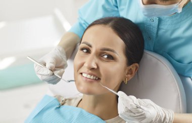 Ağız sağlığı tedavisi için diş sağlığı kliniğinde gülümseyen mutlu bir kadın, dişçi muayenesi, diş bakımı, diş bakımı, sağlıklı doktor muayenesi, diş beyazlatma prosedürü, stomatoloji modern klinik hizmetinden memnun.