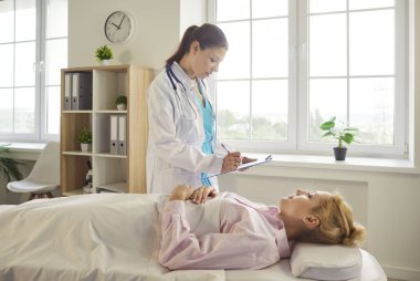 Doktor ve hasta hastane koğuşundaki sağlık kontrolü sırasında yatakta uzanıp konuşuyorlar. Steteskop tutan ciddi bir doktor. Yazmak için pano tutuyor. Muayene sonuçlarını kadınlara açıklıyor. Teşhis konsepti