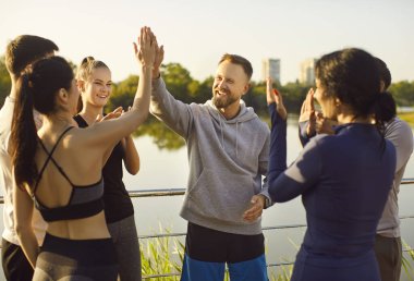 Maraton başarısının onuruna iki koşucunun zafer jesti beşliği. Mutlu formda takım arkadaşları yaz parkında spor müsabakalarının ve takım çalışmalarının bitişini kutluyor. Sağlıklı toplum kavramı