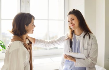 Hastane muayenesinde bir hastaya yardım eden doktor ya da hemşire. Sağlık desteği, tavsiye ve tıbbi sorunların giderilmesi ve hastanın refahının artırılması.