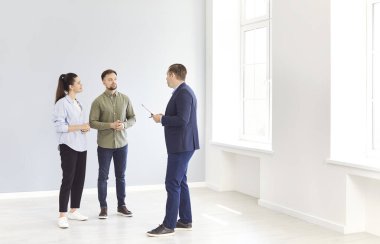 Emlakçı ya da emlakçı bir aile çiftine yeni bir mülk, ev ya da daire göstererek satın alma ya da kiralama kararından önce kilit noktaların altını çiziyor. Gayrimenkul planlama ve danışmanlık.