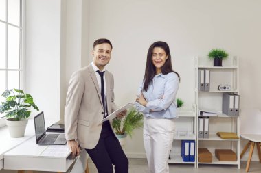 Mutlu meslektaşlar ofis odasında toplanıp sohbet ediyorlar, arkadaşça sohbet ediyorlar, iş çıkışı resmi olmayan konuşmalar yapıyorlar, çeşitli yöneticiler iş projelerini tartışıyorlar.