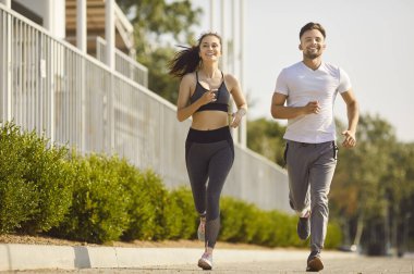 Genç insanlardan oluşan bir ekip parkta birlikte koşuyor dışarıda spor yapıyorlar. Şehir parkında doğa koşusu eğitimi alan mutlu çift. Sağlıklı yaşam tarzı ve spor konsepti. Pankart.