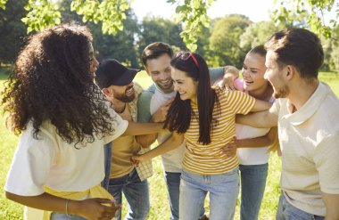 Neşeli öğrenci portresi. Yazın doğada eğlenen arkadaşlar. Güneşli bir günde eğleniyorlar. İnsanlar parkta sarılıyor. Arkadaşlık ve rahatlık kavramı.