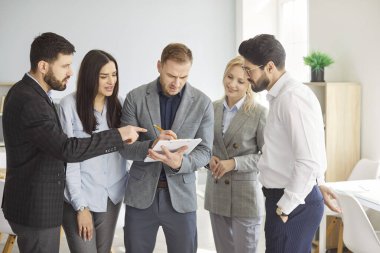 Danışman grup koçluğu, şirket planında ofis çalışanlarına yardım etmek, çeşitli meslektaşlar toplantıda birlikte çalışıyorlar, tartışıyorlar, yönetici danışmanı müvekkil, modern oda salonunda duruyorlar.