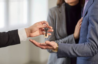 Gayrimenkul acentesinin çiftlere ev anahtarı vermesi yakın plan, emlakçı ya da komisyoncu karı ve kocayı ev satın alma ya da kiralama ile tebrik ediyor, ilk önce mutlu aile taşınıyor. 