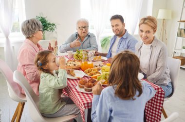 Aile, bayram kutlamalarından ya da hafta sonu evde yemek masasında oturmaktan hoşlanır. Sohbet ve paylaşılan eğlence, bir ev ortamında boş zamanların ve aile bağlarının keyfini vurguluyor..
