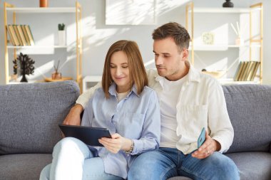 Mutlu eşler, mutlu çiftler, mutlu çiftler evde birlikte tablet bilgisayar kullanıyorlar, görüntülü konuşuyorlar, rahatlıyorlar, cep telefonlarında internet uygulamalarını paylaşıyorlar, mutlu ilişkiler kuruyorlar, online sipariş veriyorlar, 