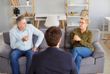 Ciddi bir terapi seansına katılan yaşlı çift anlaşmazlıkları veya kavgaları çözmek için bir psikologla sohbet ediyorlar. Görüşme sırasında yardım almak ve ilişkileri geliştirmek.