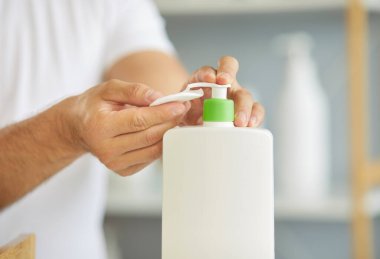 Günlük tuvalet temizleme losyonunu erkeğin temiz derisi için kullanıyorsun. Erkeklerin elinde pamuk tutarak kozmetik ürünler çıkarmak için plastik şişe dağıtıcısı var. Hijyen, cilt bakımı