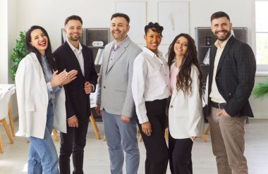 Mutlu iş adamları grubu gülümseme ve alkışlarla birlikte sıraya dizildi. Neşeli şirket çalışanları ortaklık başarısını, ofiste birlik oluşunu kutluyor. Sinerji, takım çalışması, kazanma konsepti