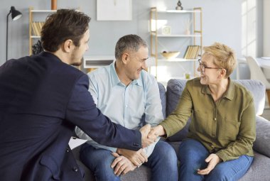 Evde hukuk uzmanına danışmak, mutlu, olgun bir aile çifti avukatla görüşen bir avukat, soru soran, konuşan, kutlayan bir anlaşma, ev ya da sağlık sigortası anlaşması yapan bir avukat.