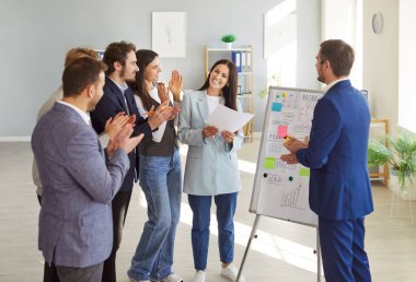 İş adamları iş toplantısında ya da bir ofiste sunumda alkışlıyorlar. Meslektaşlardan oluşan profesyonel bir ekip başarıyı kutluyor, stratejiyi tartışıyor ve işyeri faaliyetlerine katılıyor..