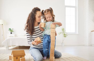Mutlu gülümseyen anne ve kız bebek bakıcısı, bebek bakıcısı küp bina oyunu, yakın arkadaş canlısı aile birlikte iyi vakit geçirin, küçük tatlı kızlı ebeveyn haftasonunun tadını çıkarın, bağlanın