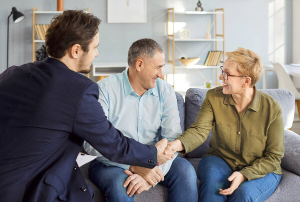 Consulting legal expert at home, happy senior mature family couple of clients meeting lawyer, solicitor asking advice, question, talking, celebrating deal, house or medical insurance buying deal