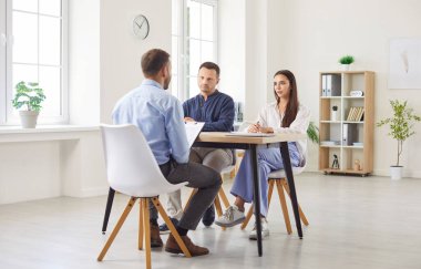 Kızgın müşteriler banka çalışanlarına müşteri şikâyetinde bulunuyor. Hoşnutsuz çift masada oturuyor, anlaşma şartlarını tartışıyor, tazminatı reddediyor, kredi onayını reddediyor, kağıtlarda hata yapıyor.