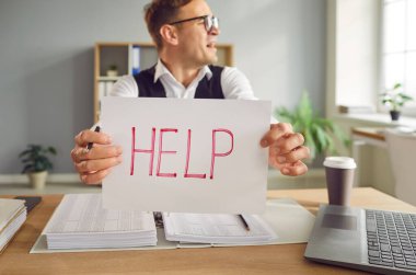 Ofisindeki masasında oturan aşırı çalışan genç muhasebeci üzgün ve yorgun bir şekilde elinde 