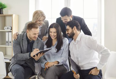 Bir araya gelen mutlu insanlardan oluşan bir ofis grubu, panoya bakarak, yazarak, tartışarak ve bilgi paylaşarak, ortak bir göreve katılarak, yeni bir şirket projesi planlayarak,