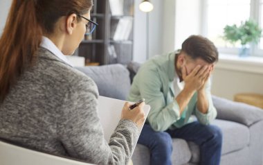 Depresyondaki üzgün adam psikologla görüşüyor, rehabilitasyonda. Psikolojik sorunu olan endişeli bir hastanın seansta profesyonel yardıma ihtiyacı var. Ruh sağlığı, depresyon kavramı