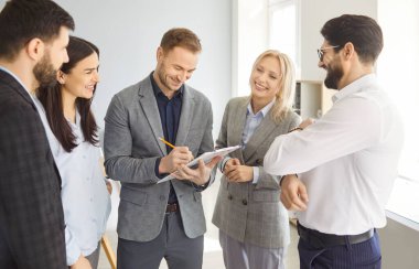 Bir grup neşeli şirket çalışanı toplantı sırasında ofiste çalışma projesini tartışıyor. Kendine güvenen genç bir iş adamı konferans odasında belgeleri imzalıyor. Takım çalışması konsepti.