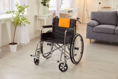 Evde duran boş tekerlekli sandalye engelli bakım, taşınabilirlik yardımı ve ulaşım desteğini sembolize ediyor. Sağlık ihtiyaçlarının temsili, rehabilitasyon ve yardım.