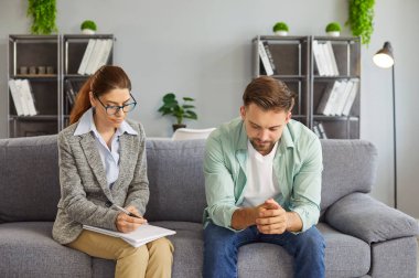 Profesyonel özel psikiyatri, danışmanlık seansı, terapist, ciddi tartışma ve içgözlem, erkek müşteri ve psikolog arasındaki konuşma, not defterine yazan psikoterapi doktoru