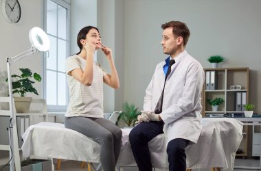 Estetik ameliyattan önce estetik cerrah veya doktorla randevuya giden kadın hasta veya doktor klinikteki güzellik prosedürü, cilt bakımı ve gelişmiş estetik sonuçlar için tıbbi odak.