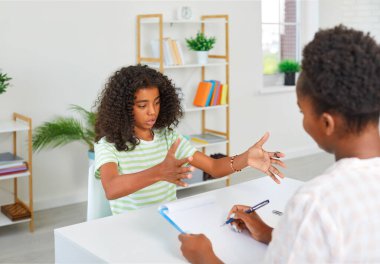 Kız, beşeri bilimler dersinde öğretmenlik sınavına giriyor aktif olarak el kol hareketi yapıyor. Hikaye, sunum, kompozisyon, edebiyat. Kitap rafları ve çiçeklerle dolu Amerikan ilkokulunun parlak iç mekanı..