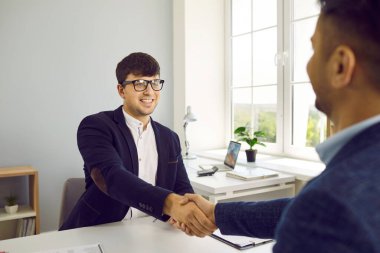 İki mutlu insan iyi bir iş anlaşması yapar ve karşılıklı güven tokalaşması yaparlar. Şirket ofisindeki masada buluşan iki genç adam gülümseyip el sıkışıyor.