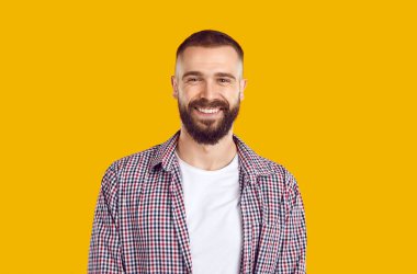 40 'lı yaşlarda sakallı, sakallı, sakallı, sade pastel renkli, sarı arka planda izole bir adam. İnsanların yaşam tarzı konsepti. Pozitif yakın plan portre.