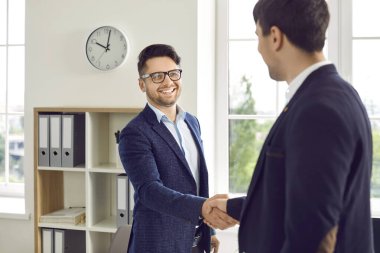 Dost canlısı iş adamı, erkek müşterisiyle el sıkışıyor ve onu ofisine davet ediyor. Takım elbiseli ve gözlüklü gülen adam yeni iş ortağı ya da şirket müşterisi olur. Buluşma kavramı