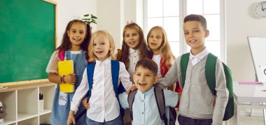 Arkadaşlar eylülün ilk gününde eğleniyorlar. Mutlu, komik okul çocuklarının toplu portresi olan pankart. Modern bir sınıfta kameraya bakıp gülümseyen neşeli beyaz öğrenciler.