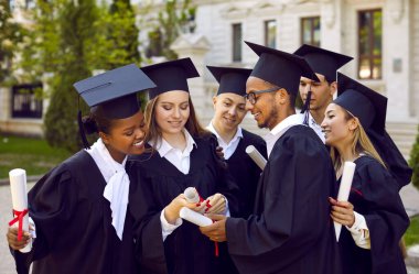 Artık birlikte okuduk, birlikte mezun oluyoruz. Üniversite öğrencileri mezuniyet töreninden sonra birbirlerine diplomalarını gösterirler. Grup geleneksel cüppeler ve kare şapkalar giyer..