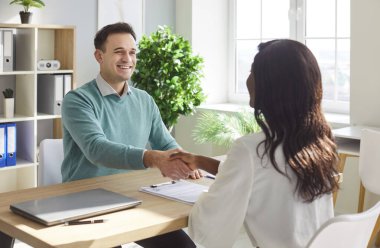 Genç erkek müvekkil ofisinde anlaşmak için Afrikalı Amerikalı kadınla buluşuyor, danışmanlık yapıyor, tokalaşıyor, insan kaynakları danışmanlığı için teşekkür ediyor, avukat, broker, danışman, emlakçı, doktor