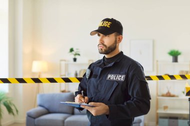 Polis soruşturmasına ilişkin belgeleri dolduran, hırsızlık ya da suç delillerini toplayan, veri raporu yazan, suç mahallinde poz veren ciddi polis memurlarının kapalı çekim görüntüleri.