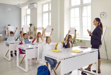 Tüm sınıf sorulan soruya cevap verirken mutlu bir şekilde ellerini kaldırdı. Kafkas okul öğrencilerinden oluşan zeki bir grup. Kuzey Avrupa ülkelerinde ücretsiz eğitim.