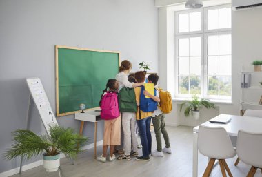 Öğretmenimizi seviyoruz. Mutlu ilkokul çocukları bayan öğretmenlerine sarılıp teşekkür ediyorlar ya da okula dönüşünü kutluyorlar. Sırt çantalı okul çocukları okulda kadınlara sarılıyorlar..