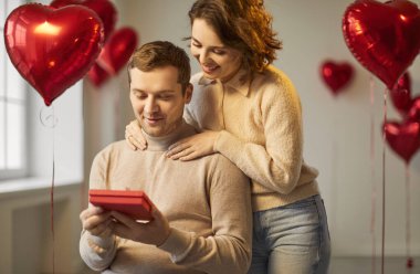 Sevgi dolu yakın çift hediye kutusunda, erkek, kadın hediye paketi, kırmızı kalp sembolü, romantik sevgililer günü balonları duygu, sevgi, erkek ve kadın çifti romantizmin ifadesi.