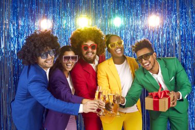 Çok uluslu, şampanyalı bardakları tıkırdatan bir grup gencin portresi. Arkadaşlar parlak kostümler, parlak yağmurun arka planında sahte elmaslar olan büyük disko bardakları giyerler.