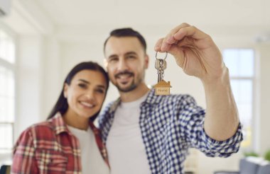 Parlak bir çift, şimdi mutlu bir aile, ellerinde yeni dairenin anahtarları var. Bu cesaret verici an, yeni mülklerin sahipliğini kucakladıkları hayatlarının mutlu bir bölümünün başlangıcını simgeliyor..