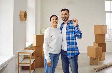 Mutlu aile çifti yeni modern dairelerinin anahtarlarını aldı ve onları kamerada gösterdi. Yeni evlerini alan evli bir çift. Gayrimenkul, taşınma, mülk, konut.