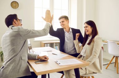 Mutlu, heyecanlı genç çift ofis masasında başarılı bir anlaşma yaparken finans danışmanı, borsacı, emlakçı ya da emlakçıya beşlik çakıyor.