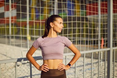 Kendine güvenen sporcu bir sporcunun portresi. Spor sonrası parkta durup sporu izleyen ve yan tarafa bakan bir kadın. Açık hava sporu ve sağlıklı yaşam tarzı konsepti.