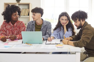 Ofisteki iş ekibi toplantı sırasında mali belgelerle birlikte çalışıyor. Takım çalışması, bir grup insan önemli iş görevlerine odaklandığı için işbirliğini vurguluyor.