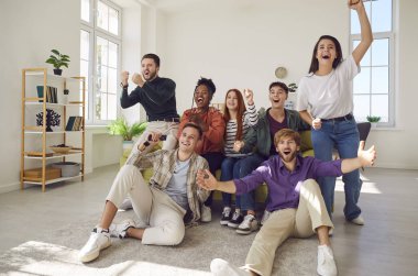 Heyecanlı, mutlu, çeşitli arkadaş gruplarının televizyonda en sevdikleri takımı destekleyen bir spor maçı izlemesi portresi. Arkadaşlık, kiralama, spor, ev partisi konsepti.