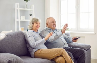 Yaşlı, yaşlı bir çift birlikte televizyon izliyor, evdeki kanepede dinleniyor, TV ile boş zamanlarının tadını çıkarıyorlar. Bu rahatlama ve beraberlik anı güçlü bir bağı vurgular..