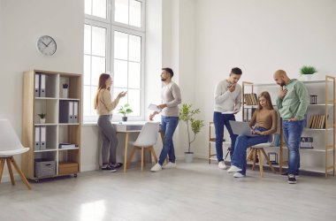 İnsanlar günlük yaşamlarını bir ofis işyerinde sürdürüyorlar. Birkaç genç erkek ve kadın çalışan iş yerinde buluşup iş kurma projelerini tartışıyorlar. İş, yaşam tarzı konsepti 