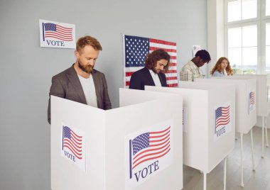 Kendine güvenen genç Amerikan vatandaşlarının portresi. Seçim günü oy verme kabininde oy veren kadın ve erkekler oy kullanma merkezinde duruyor..